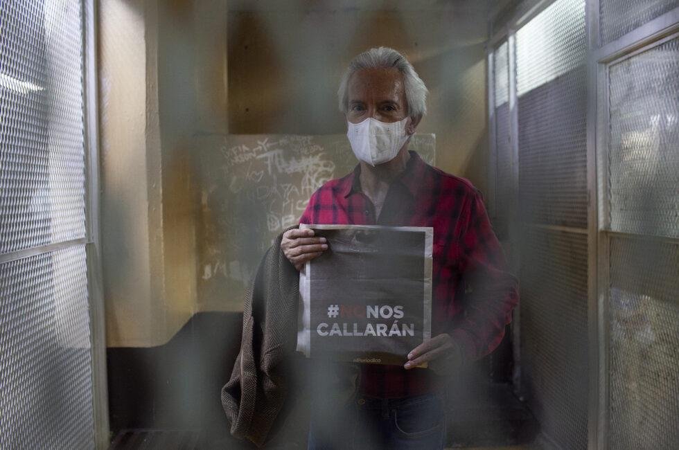 José Rubén Zamora, tras una reja, sostiene una portada de elPeriódico con el titular «#NoNosCallarán».