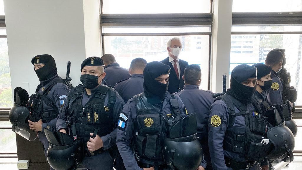 Un cordón de policías antimotines rodea a José Rubén Zamora en un pasillo del edificio judicial. Foto: La Hora / José Orozco.